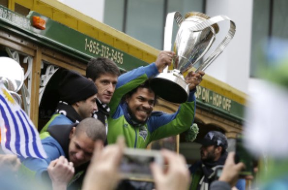Seattle Sounders' Roman Torres holds the MLS Cup Championship trophy as the team begins a march and rally celebrating their victory, Tuesday, Dec. 13, 2016, in Seattle. Seattle beat Toronto FC 5-4 in a penalty kick shootout Saturday to win their first MLS championship. (AP Photo/Elaine Thompson)